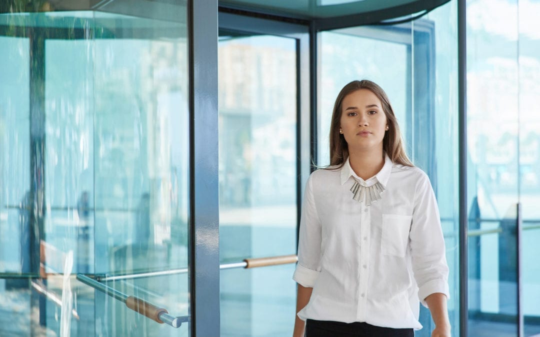 Pretty Businesswoman Standing In Front Of Revolving Door